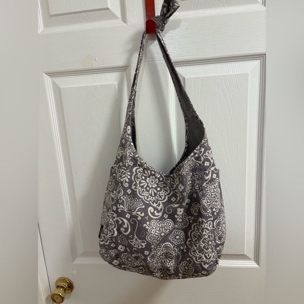 Thirty-One Retro Metro Hobo Crossbody in a gray floral and reverses to gray dots